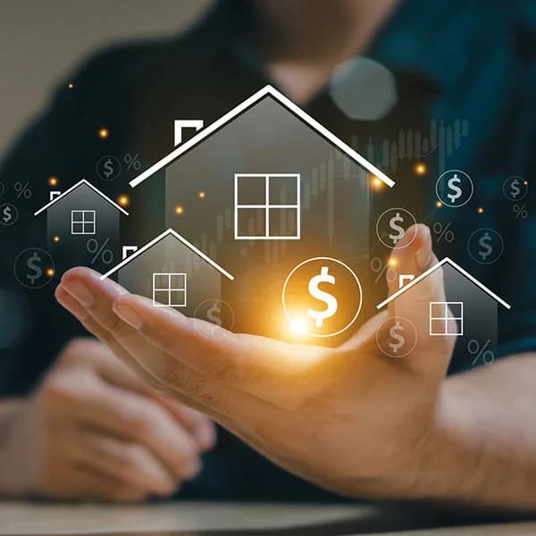 A hand holding small house illustrations overlaid with dollar and percent symbols, illustrating home equity concepts
